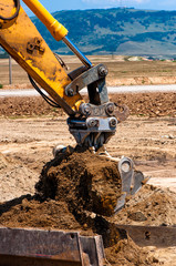 heavy duty excavator loading sand into a dumper truck
