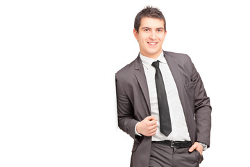 Smiling male businessman leaning against wall
