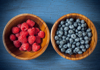 Raspberries and blueberries in a wooden bowl