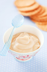 Caramel cream in a ceramic bowl and waffles, selective focus