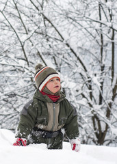 Fototapeta na wymiar Child toddler standing and walking in deep snow in winter.
