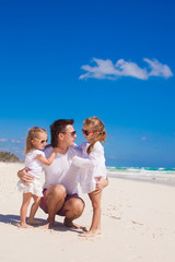 Happy father and his adorable little daughters on sunny day