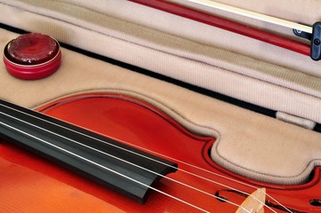 Viola in its case showing fingerboard, bow and rosin