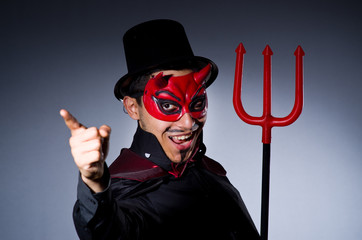 Man in devil costume in halloween concept