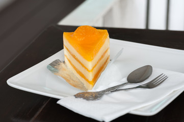 Orange cake on white dish at coffee shop