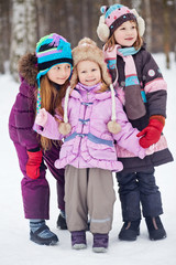 Three girls - two older and one younger - stand together