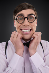 Happy nerd. Young cheerful nerd man in glasses smiling while iso