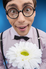 Nerd with flower. Young nerd man holding flower and smiling whil