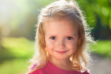 Outdoor portrait of cute little girl in summer day