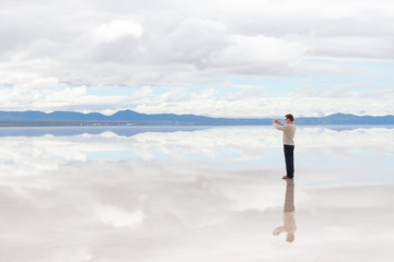 Man taking pictures on the lake Salar de Uyuni, Bolivia