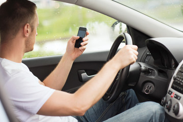 man using phone while driving the car
