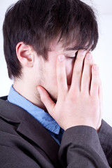 Fototapeta premium Young man holding his hands over his face