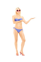 Happy blond female in bikini gesturing with her hand
