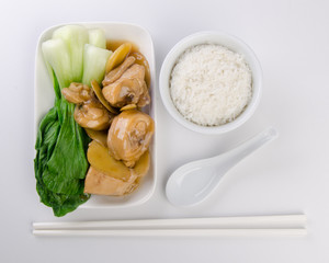 Chicken with rice and vegetables in background