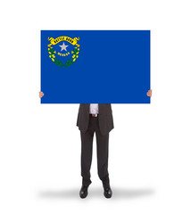 Smiling businessman holding a big card, flag of Nevada