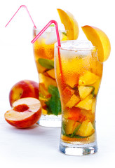 Glass of fruit iced peach Mojito cocktail with mint
