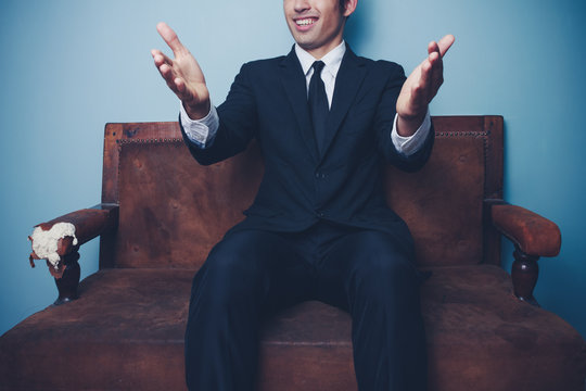 Businessman on sofa gesturing with his hands