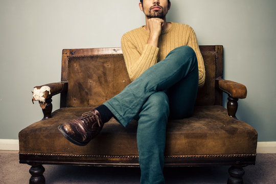 Young Man On Couch Deep In Thought