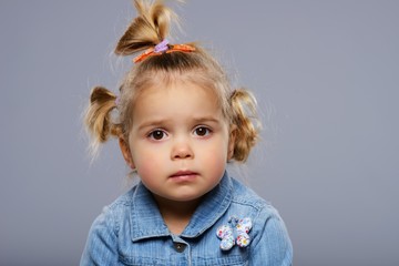 Disappointed little girl isolated on grey background