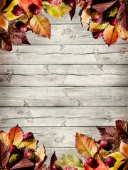 Naklejka premium Autumn border from apples and fallen leaves on old wooden table