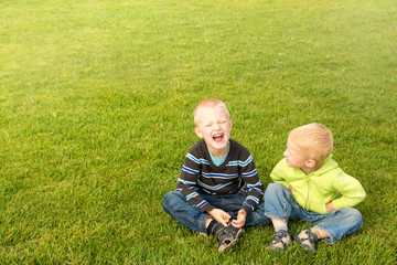 Naklejka na ściany i meble Happy children on green grass