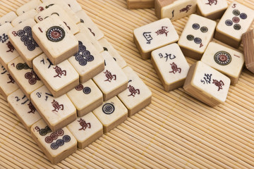 Old chinese game mahjongg on bamboo mat background