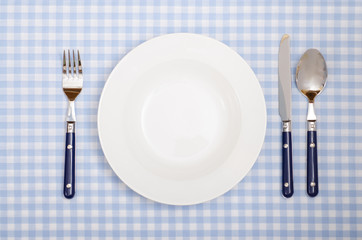 Gedeck aus Messer, Gabel, Löffel und Teller im Restaurant