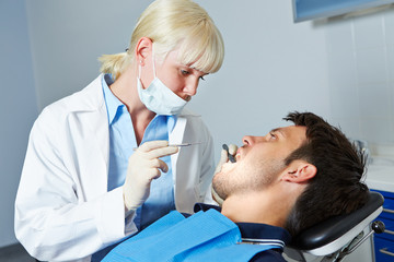 Fototapeta premium Dentist examining patient with toothache