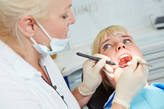 Dentist examining patient with probe