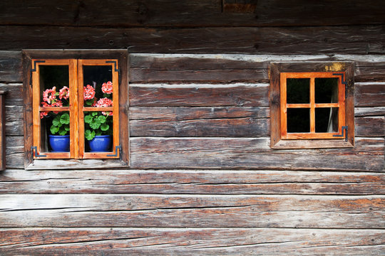 altes &ouml;sterreichisches Blockhaus mit Geranien am Fenster