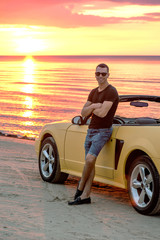 Man with super car on back of sunset