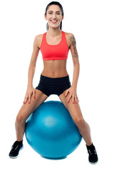 Woman in gym relaxing on pilates ball