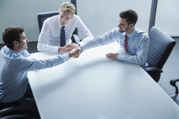 Businessmen shaking hands over the table in the office