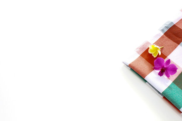 Thailand fabrics adorned with orchids and frangipan on a white background