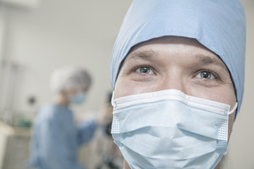 Fototapeta na wymiar Portrait of surgeon with surgical mask and surgical cap in the operating room 
