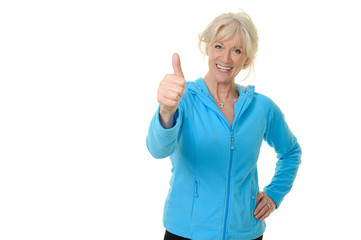 Sportliche Seniorin hält Daumen nach oben