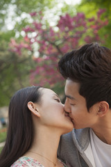 Obraz premium Young couple in love and kissing outdoors in the park