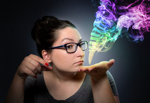 Woman looks at the mystical colored smoke. Daydream concept