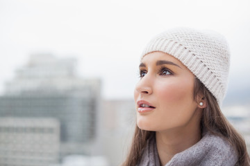 Thoughtful cute woman with winter clothes on posing