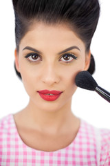 Gorgeous black hair model applying powder on her cheek