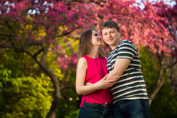 Fototapeta premium Happy loving couple are hugging blossoming apple orchard