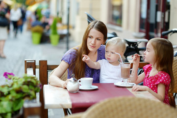 Mother and her daughters relaxing in outdoor cafe