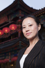 Portrait of businesswomen with Chinese architecture in background.