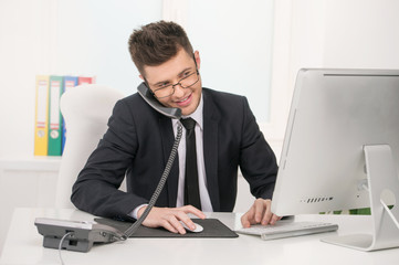 Cheerful businessman. Cheerful young man in formalwear sitting a