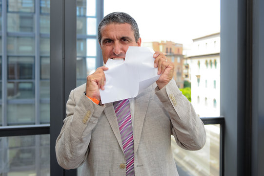 Uomo d'affari che strappa un foglio