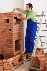 Fototapeta premium Worker building masonry heater