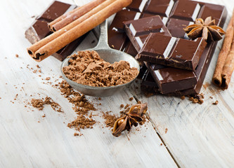 Broken chocolate bar and spices .