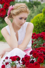Woman sitting among pink rose garden