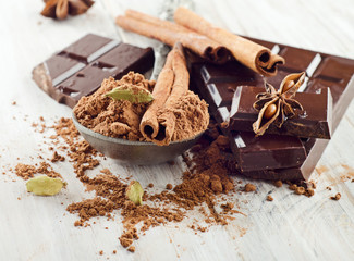 Broken chocolate bar and spices .