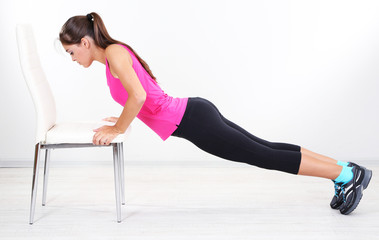 Obraz premium Beautiful young girl doing exercises at home